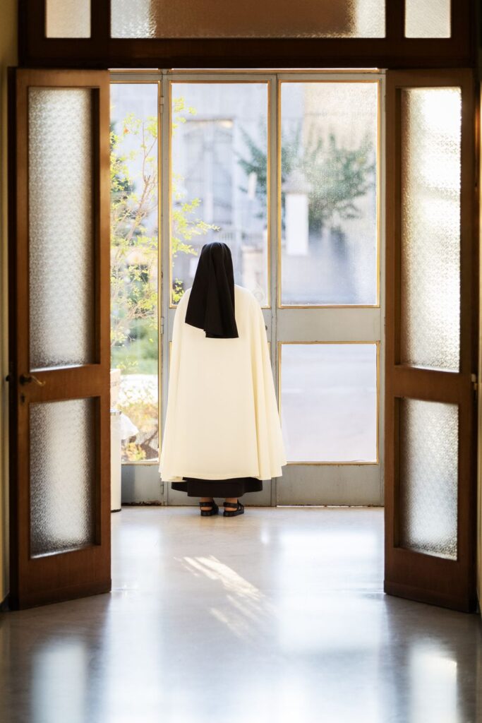 Una suora sulla soglia della chiesa, vista di spalle – Professione perpetua, Parrocchia Buon Pastore, Bari, 26 settembre 2026