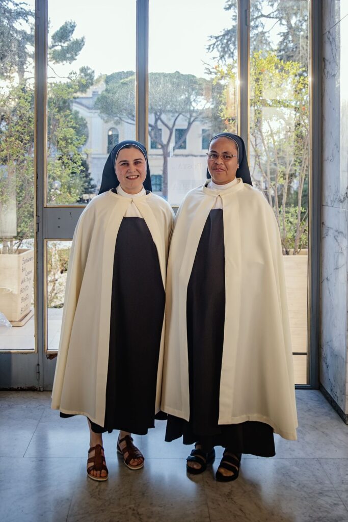 Le due suore con il mantello bianco accanto alle vetrate della chiesa – Professione perpetua, Parrocchia Buon Pastore, Bari, 26 settembre 2026