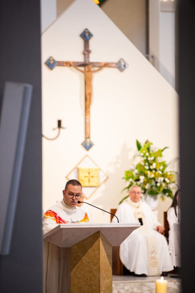 Un sacerdote all'ambone sotto il crocifisso – Professione perpetua, Parrocchia Buon Pastore, Bari, 26 settembre 2026
